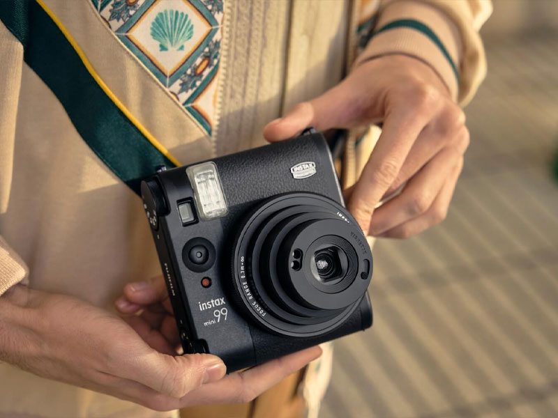 دوربینFujifilm Instax mini 99 در دستان عکاس مرد