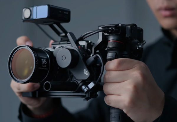 موتور فوکوس دی جی ای DJI RS Focus Motor 2022 و گیمبال dji در دست مرد در حال فیلمبرداری