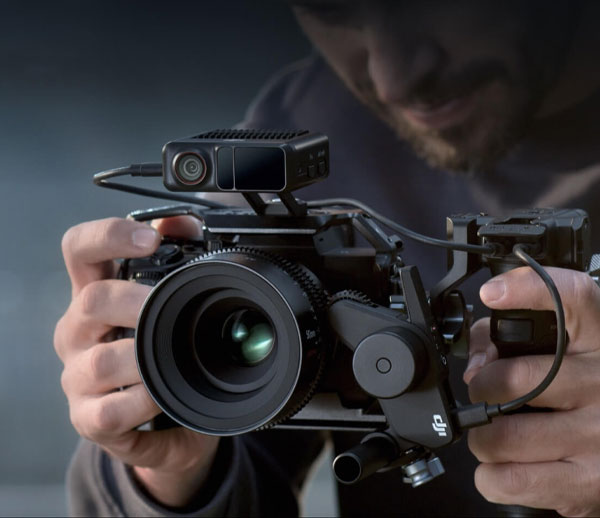 موتور فوکوس دی جی ای DJI RS Focus Motor 2022 و دوربین در دست مرد در حال فیلمبرداری