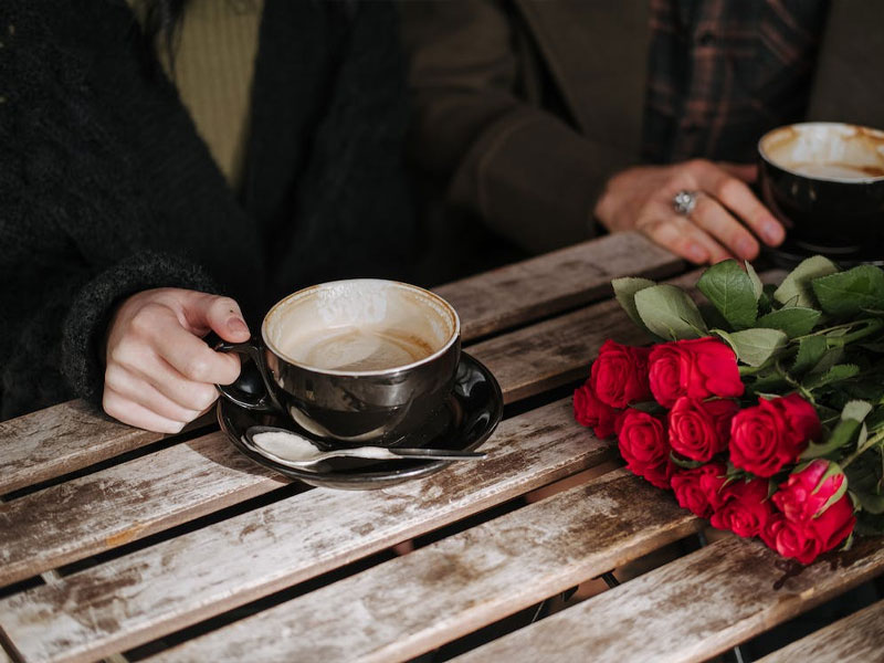 ژست عکاسی در کافه و فنجان و گل رز روی میز
