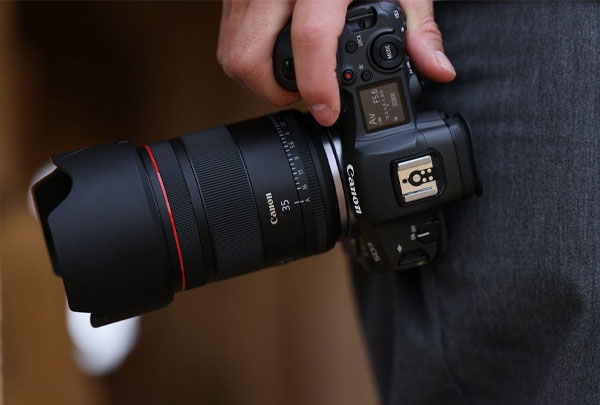 لنز کانن Canon RF 35mm f/1.4 L VCM و دوربین در دست مرد