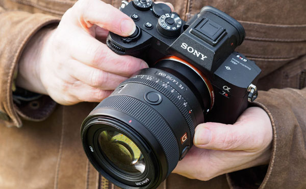 لنز سونی Sony FE 50mm f/1.4 GM Lens و دوربین در دست عکاس