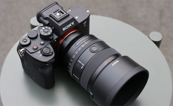 لنز سونی Sony FE 50mm f/1.4 GM Lens و دوربین روی میز