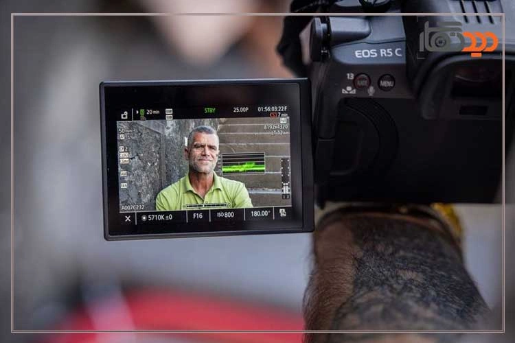 نقد و بررسی دوربین کانن R5 C و نمای جانبی بدنه دوربین در دست عکاس